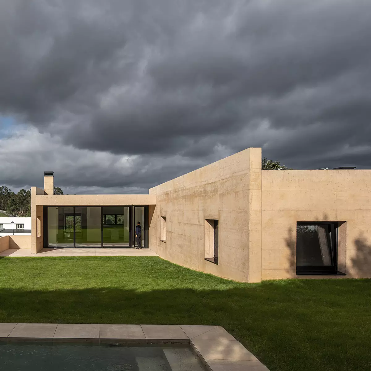 Fachada de vivienda unifamiliar en A Coruña diseñada por SEA Arquitectos con muros de hormigón visto.