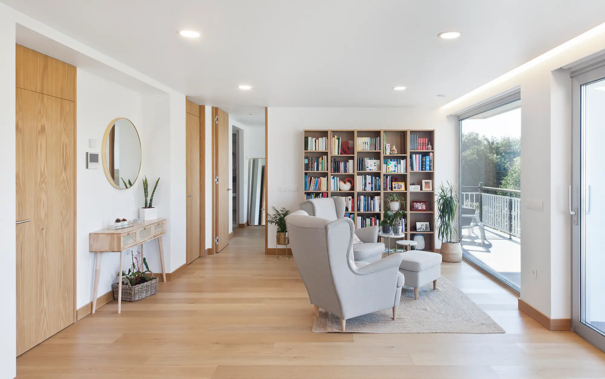 Salón luminoso con rincón de lectura y terraza en vivienda en Ferrol. Diseño por SEA Arquitectos.