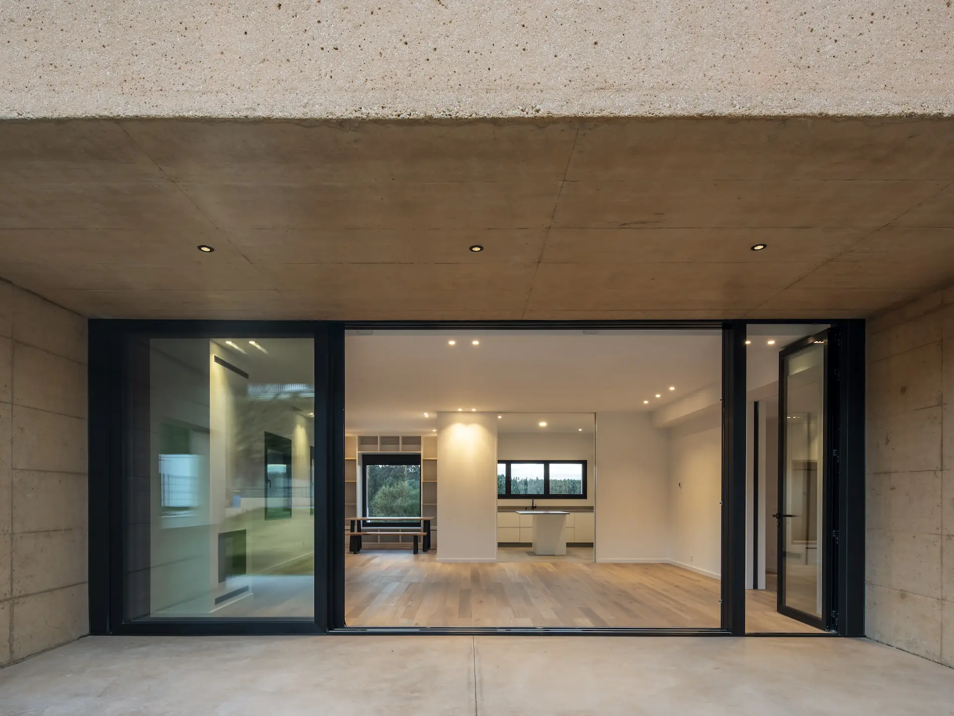 Interior de vivienda unifamiliar contemporánea con gran apertura acristalada al porche, diseñado por SEA arquitectos.
