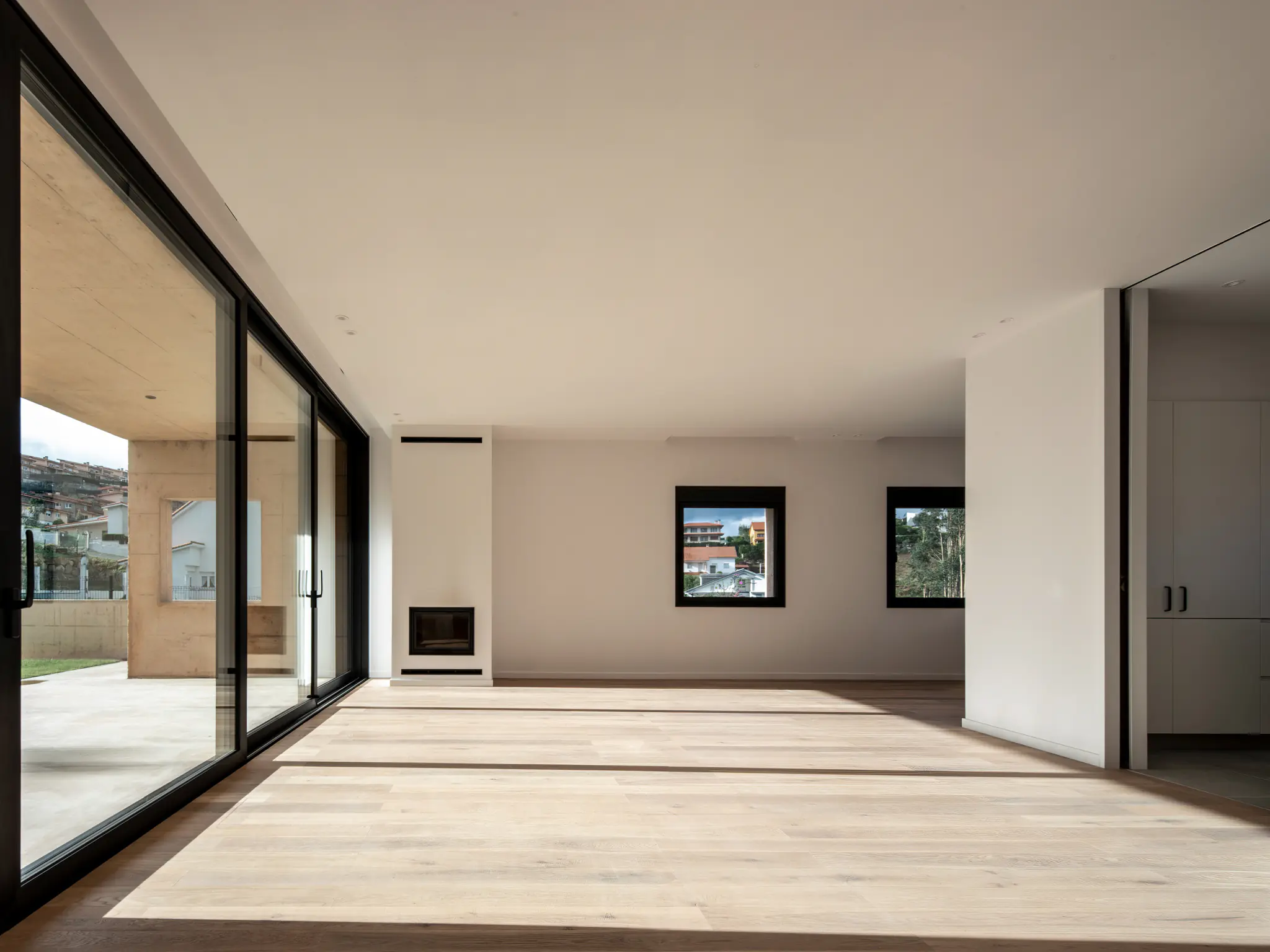 Espacio diáfano de vivienda con iluminación natural y carpinterías negras, por estudio de arquitectura SEA.