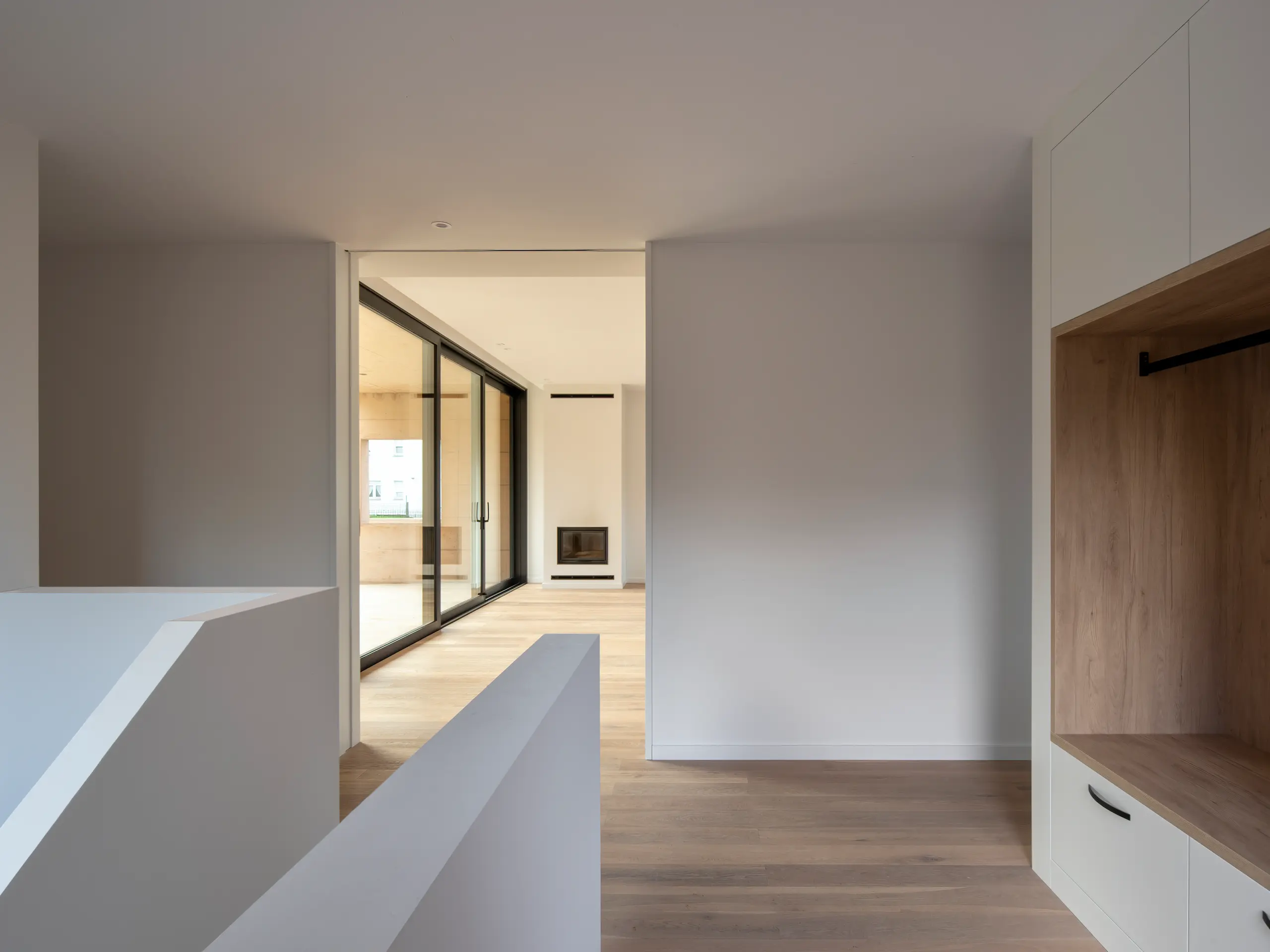 Distribuidor interior de vivienda contemporánea con vistas al salón, por arquitecto en A Coruña.
